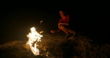 Youg woman roast marshmallow on fire
