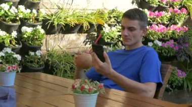 Young man sitting at the table with coconut drink