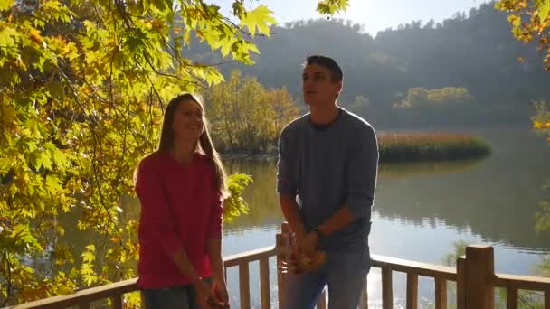 Feliz jovem casal vomita folhas — Vídeo de Stock