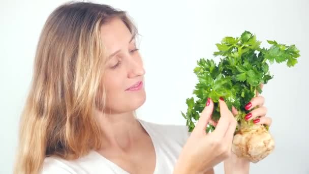Young pretty woman holding fresh celery root — Stock Video