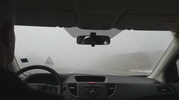 Driving a car on the road in foggy day. Low visibility. Smoke on the road. — Stock Video