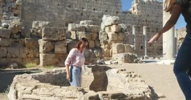 Young female tourists walking in Ancient city Perge, open air antique historical museum