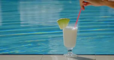 womans hand stir cocktail