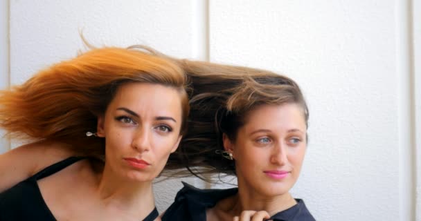 Dos mujeres jóvenes con el pelo volador — Vídeo de stock