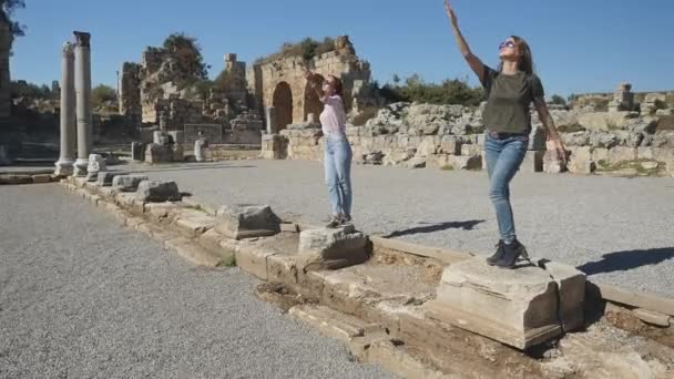Девушки позируют на руинах древнего города — стоковое видео