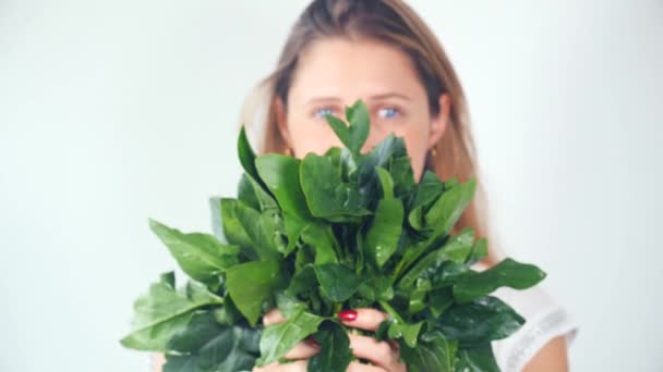 Defocused young woman showing fresh spinach — Stock Video