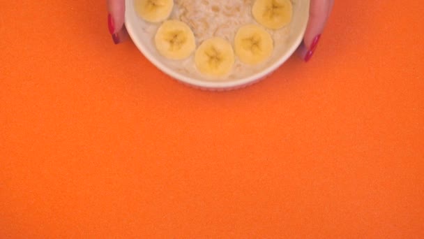 Ciotola in ceramica con porridge di farina d'avena con banane e fragole — Video Stock