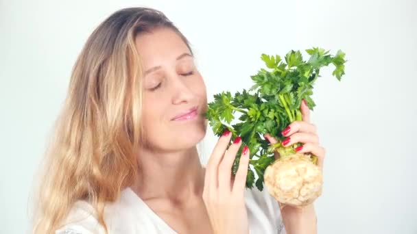 Mladá hezká žena drží čerstvý celer kořen — Stock video