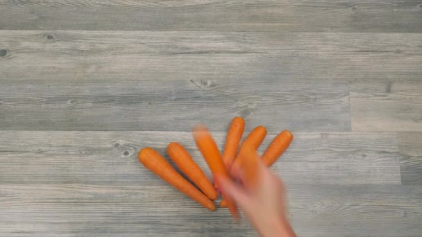 Mulher coloca cenouras na forma de uma timelapse coração — Vídeo de Stock