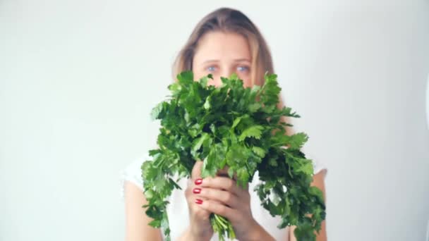 Portrait of a beautiful happy young woman giving bouquet of fresh parsley — Stock Video