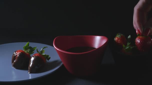 Dippen van aardbei in chocolademengsel — Stockvideo