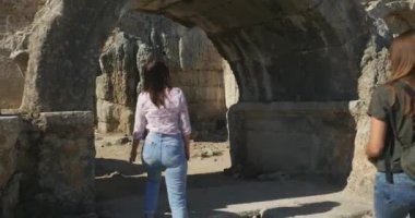 Young female tourists walking in Ancient city Perge, open air antique historical museum