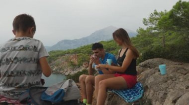 Ormanda kayalıklarda piknik yiyen aile