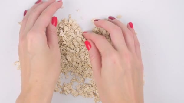 Mujeres manos haciendo corazón de copos de avena — Vídeos de Stock