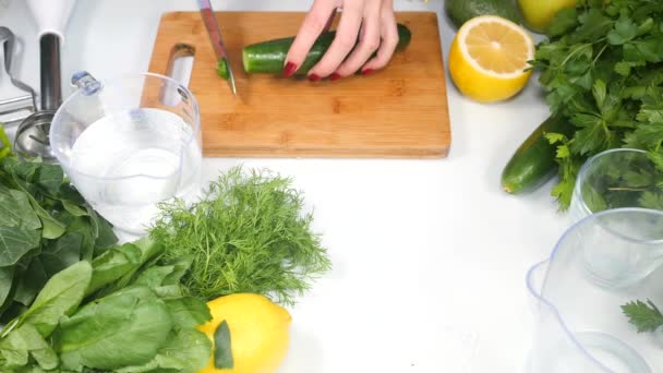 Vrouwen handen met behulp van plantaardige peeler om de huid van een komkommer te halen — Stockvideo