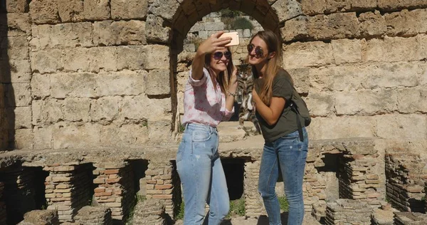 Los turistas toman fotos cerca de la arquitectura romana del templo antiguo en el museo al aire libre —  Fotos de Stock