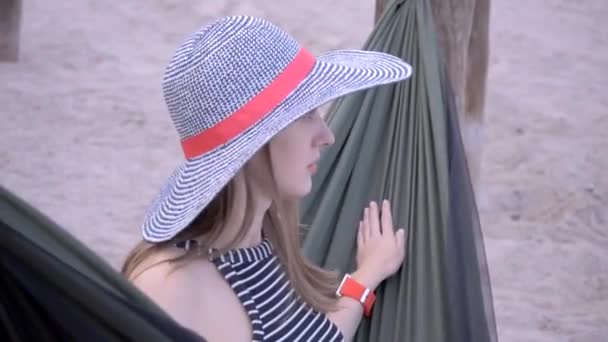 Молодая женщина отдыхает на гамаке — стоковое видео