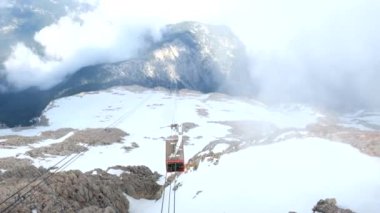 Bulutlu havalarda aşağı hareket eden bir teleferiğin görünümü