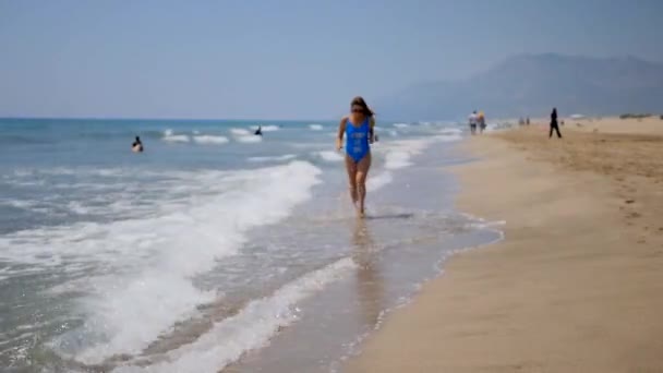 Young woman running down the sandy beach. — Stock Video