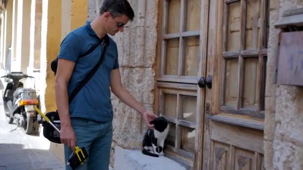 Чоловік погладжує кота — стокове відео