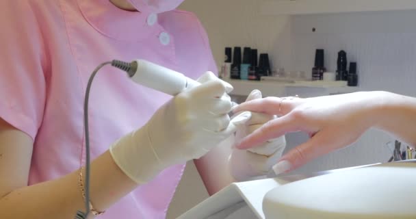 Vrouwelijke manicure verwijdert oude gel van klanten nagels. — Stockvideo