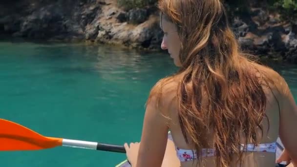 Denizde kanoyla kayak yapılan bir kadının arka görünümü. — Stok video
