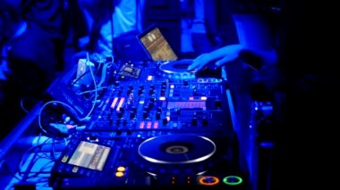 Dj mavi ışık altında kulüpte kayıtları döner