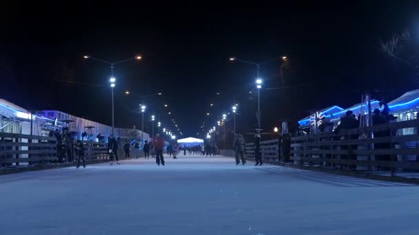 Menschen skaten auf der Eisbahn im Park — Stockvideo