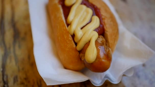 Hete hond met mosterd, op een broodje op de plaat — Stockvideo