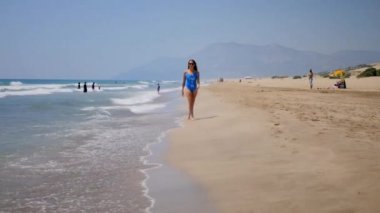 Tatil seyahat bikini kadın kumlu plajda yürüyüş