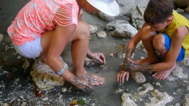 Женщина размазывает грязь по телу — стоковое видео