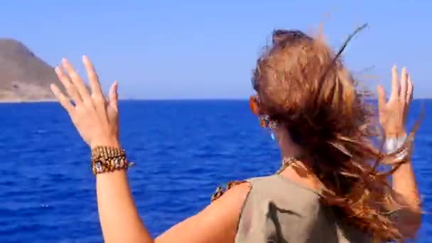 Una joven admira el mar desde la cubierta de un barco . — Vídeos de Stock