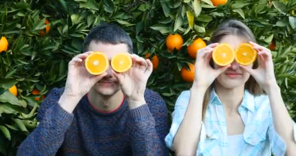 Junge Familie mit Orangenscheiben im Scherz — Stockvideo