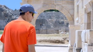 Taş üzerindeki Antik Yunan yazılarına bakan adam