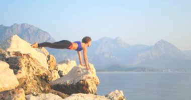 Spor kadın kayalar üzerinde yoga yapma