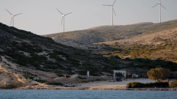Електрогенератори вітрових турбін на узбережжі океану на заході сонця . — стокове відео