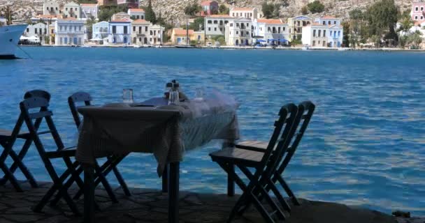 Деревянный стол и стулья, приготовленные для клиентов на берегу моря — стоковое видео
