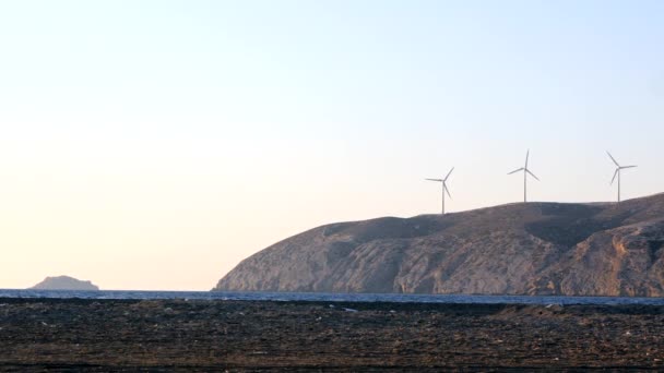 Windturbinestroomgeneratoren aan de oceaankust bij zonsondergang. — Stockvideo