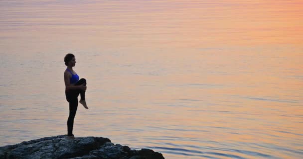 Girl practices yoga near the ocean — Stock Video