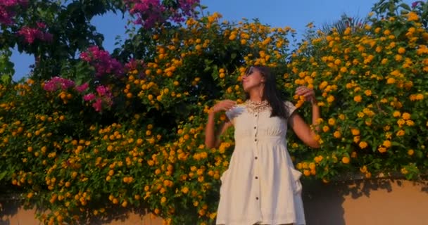 Mooie vrouw op de bloemen muur achtergrond — Stockvideo