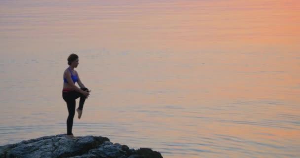 Girl practices yoga near the ocean — Stock Video