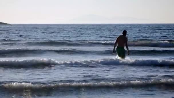 Joven va a nadar en el mar — Vídeos de Stock