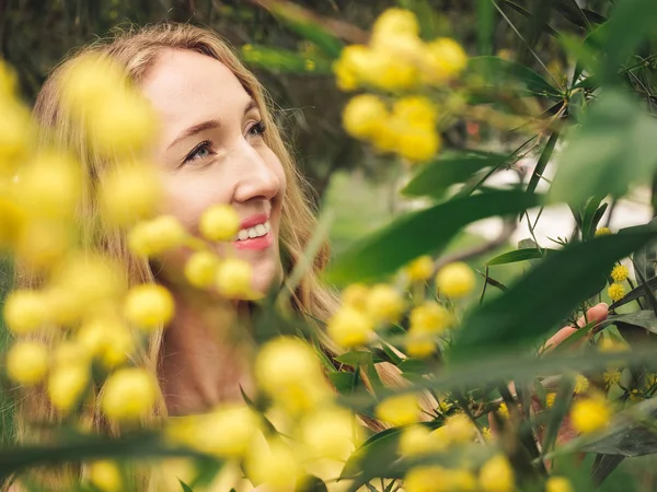 Young beautiful smiling woman in spring Australian Golden wattle trees. — Stock Photo, Image
