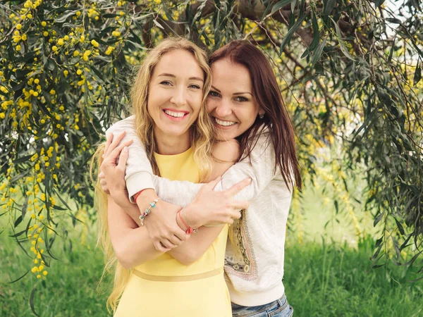 Jeunes belles femmes souriantes au printemps Australian Golden wattle trees . — Photo