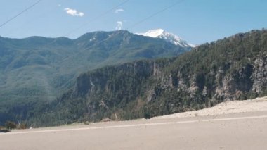 Güneşli bir günde açık havada valiz otostop ile kırsal yolda güzel genç bayan