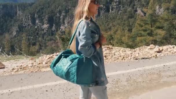 Schöne junge Dame in Jeans-Kleidung mit großer Handtasche trampen sonnigen Tag im Freien — Stockvideo