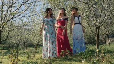 Bahar çiçekleri arasında uzun elbiseler içinde genç güzel kadınlar..