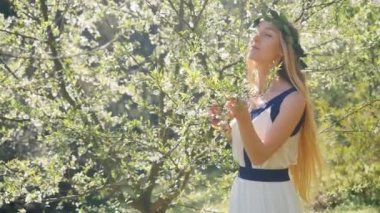 Genç ve güzel bir kadın çiçek ağaçlarının kokusunu alır..