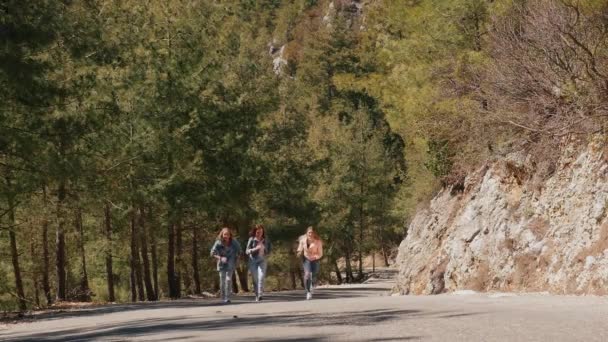 Árvore jovem mulher em jeans desgaste se divertindo na estrada da floresta — Vídeo de Stock