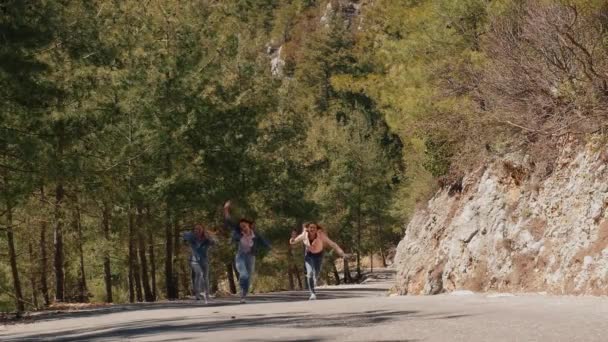 Árvore jovem mulher em jeans desgaste se divertindo na estrada da floresta — Vídeo de Stock